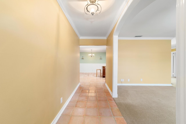 corridor with tile patterned flooring, crown molding, and an inviting chandelier