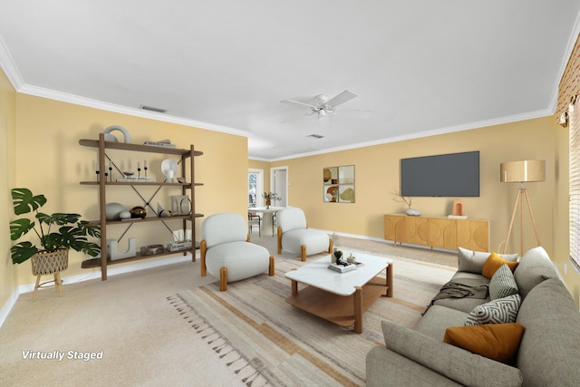 living room with ceiling fan, light carpet, and crown molding