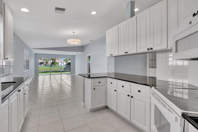 kitchen featuring vaulted ceiling, white cabinetry, light tile patterned floors, kitchen peninsula, and white appliances