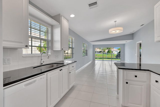 kitchen with vaulted ceiling, light tile patterned flooring, white cabinetry, sink, and white dishwasher