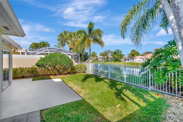 view of yard with a water view and a lanai