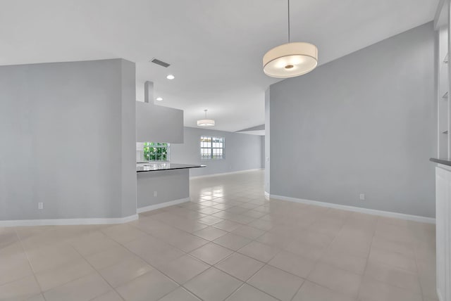 empty room featuring lofted ceiling and light tile patterned floors