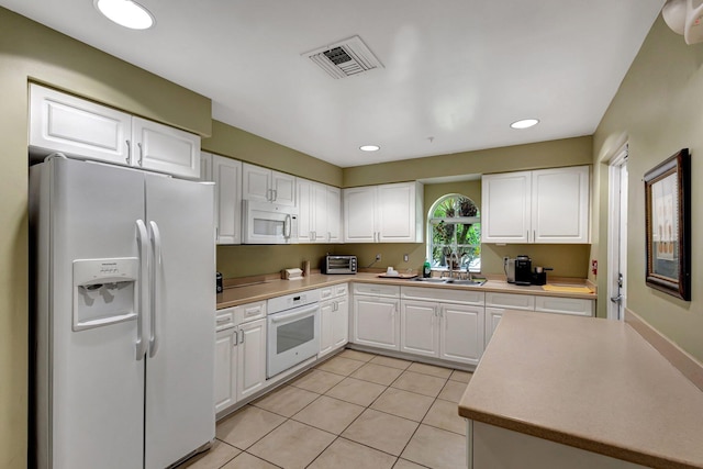 kitchen with white cabinetry, white appliances, sink, and light tile patterned floors