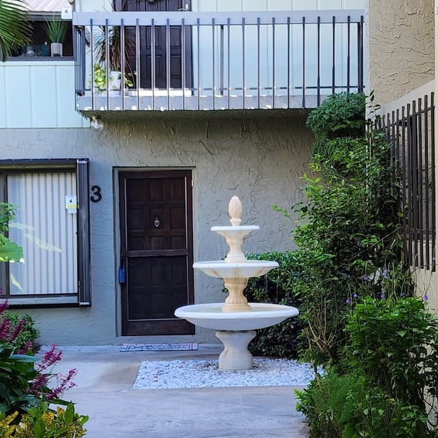 view of exterior entry featuring a balcony