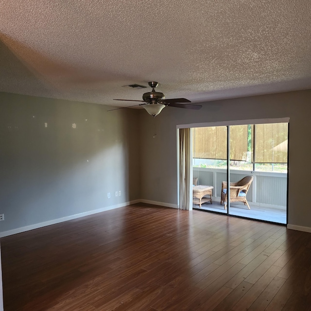 spare room featuring ceiling fan, dark wood-type flooring, and a textured ceiling