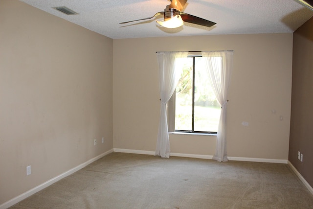 carpeted empty room with ceiling fan and a textured ceiling