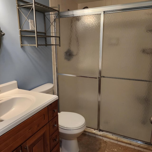 bathroom with tile patterned flooring, vanity, an enclosed shower, and toilet