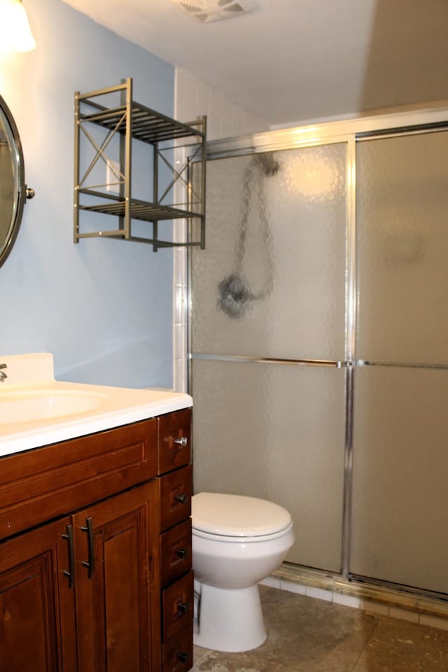 bathroom featuring vanity, toilet, and a shower with door