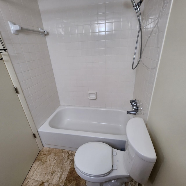 bathroom featuring toilet and tiled shower / bath combo