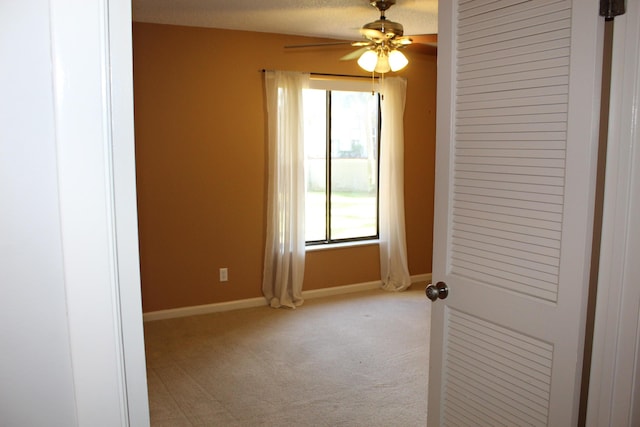 carpeted spare room with ceiling fan