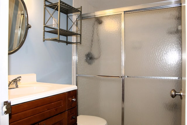 bathroom featuring vanity, toilet, and walk in shower