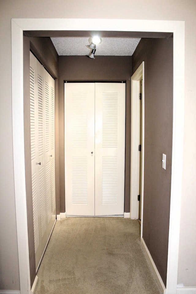 hall with carpet floors and a textured ceiling