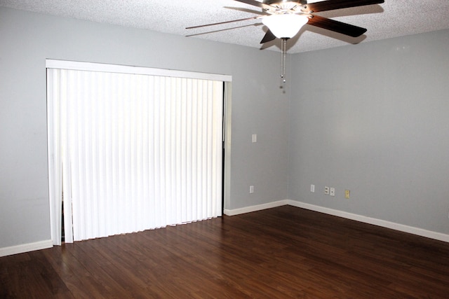 empty room with ceiling fan, dark hardwood / wood-style floors, and a textured ceiling