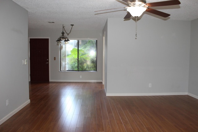 unfurnished room with dark wood-type flooring, ceiling fan with notable chandelier, and a textured ceiling