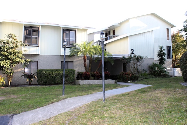 view of front of property with a balcony and a front lawn