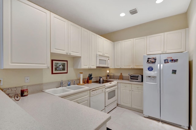 kitchen with white cabinets, white appliances, sink, and light tile patterned floors