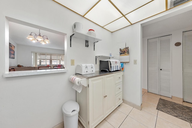 kitchen featuring pendant lighting, light tile patterned floors, and a chandelier