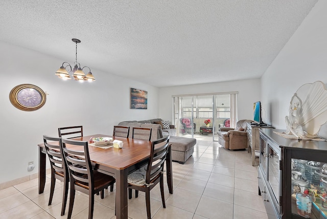 dining space with light tile patterned flooring, a chandelier, and a textured ceiling