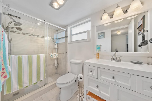 bathroom featuring tile patterned floors, vanity, toilet, and an enclosed shower