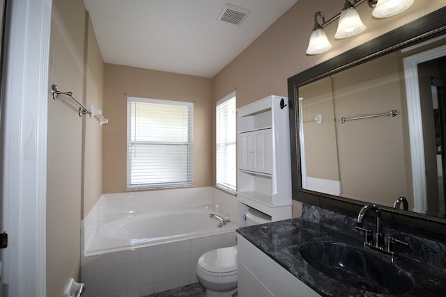 full bath with visible vents, a garden tub, vanity, and toilet