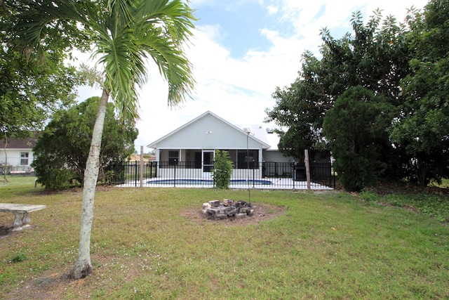 view of yard featuring a fenced in pool, an outdoor fire pit, a sunroom, and fence