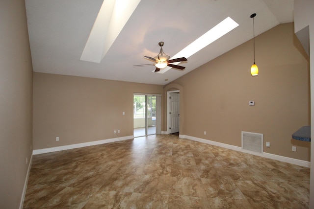 unfurnished room featuring ceiling fan, vaulted ceiling with skylight, arched walkways, visible vents, and baseboards