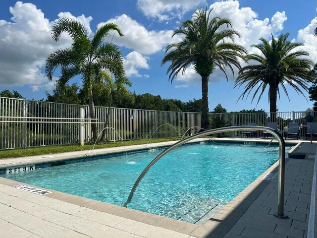 view of swimming pool with pool water feature and a patio