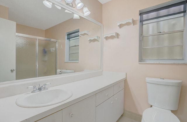 bathroom featuring vanity, toilet, and walk in shower