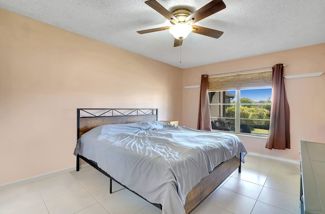 tiled bedroom featuring ceiling fan and a textured ceiling