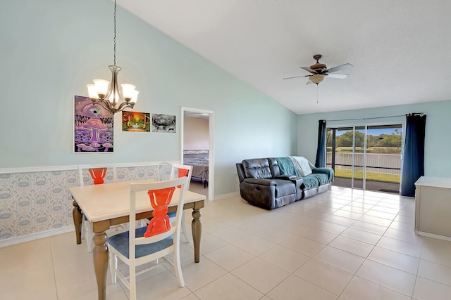 tiled dining space with ceiling fan with notable chandelier and lofted ceiling