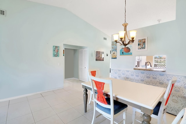 dining area with a chandelier, light tile patterned floors, and vaulted ceiling