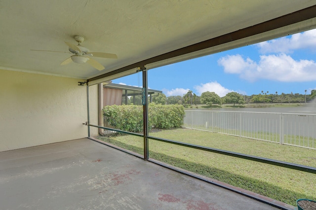 unfurnished sunroom with ceiling fan