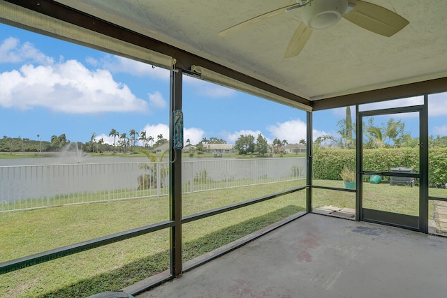 unfurnished sunroom with a water view and ceiling fan