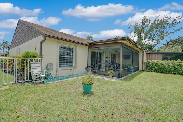 back of house with a lawn and a sunroom