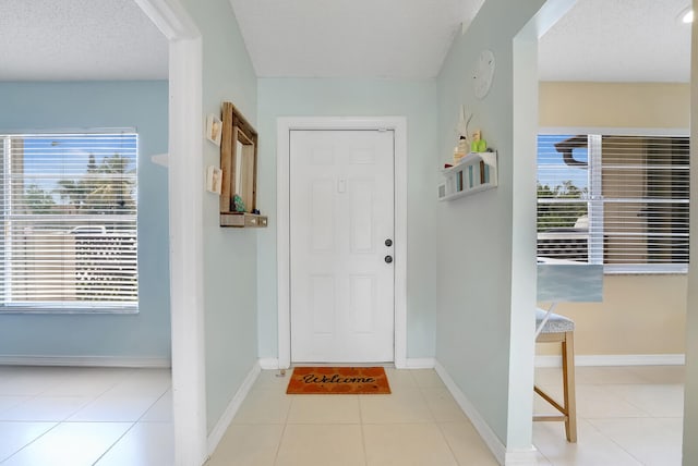 foyer featuring light tile patterned floors and a textured ceiling