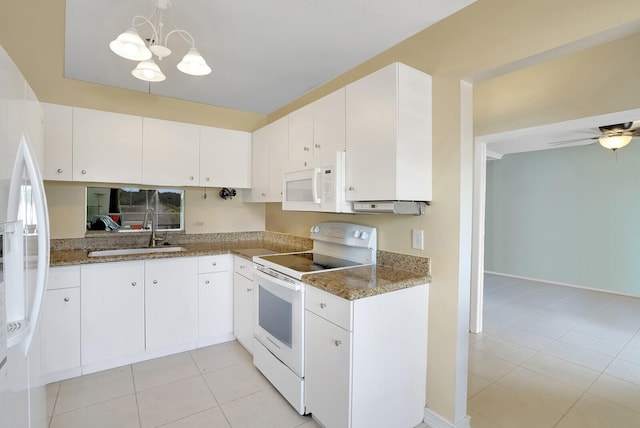 kitchen featuring white appliances, sink, decorative light fixtures, white cabinetry, and light tile patterned flooring