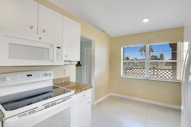 kitchen with white appliances, white cabinets, light tile patterned floors, a textured ceiling, and stone countertops