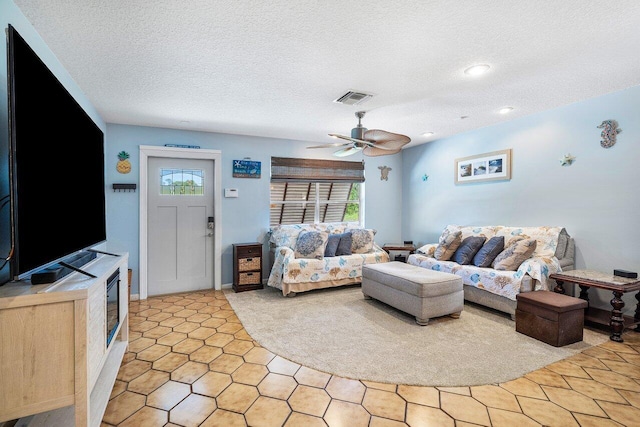 living room featuring a wealth of natural light, ceiling fan, and a textured ceiling