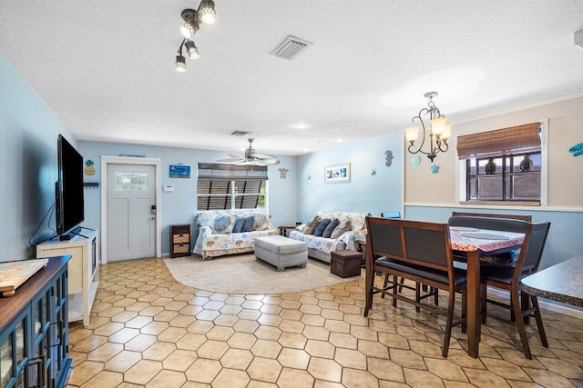 dining space with ceiling fan with notable chandelier and a textured ceiling