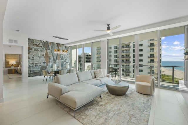 tiled living room with a water view, floor to ceiling windows, and ceiling fan