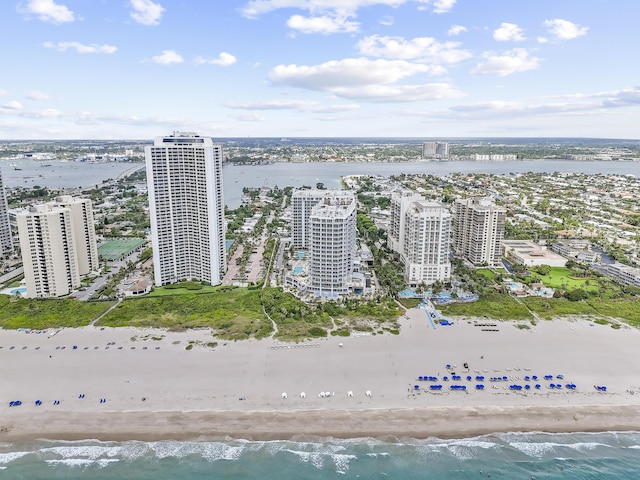 birds eye view of property with a water view and a beach view