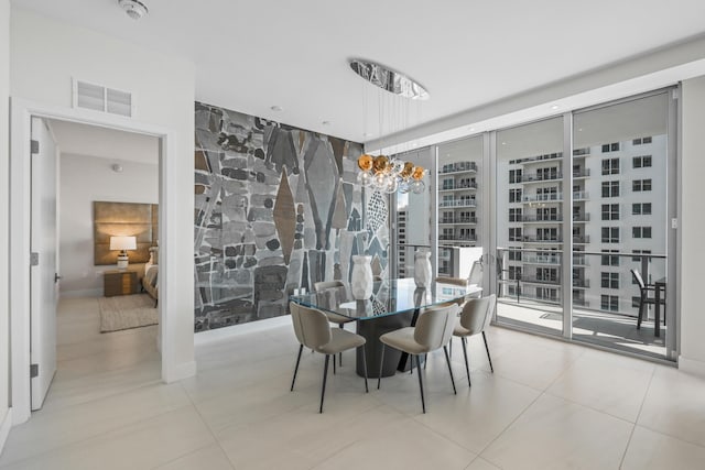 dining area with light tile patterned floors and a wall of windows