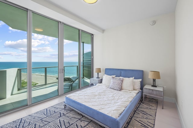 bedroom featuring access to exterior, a water view, and a view of the beach