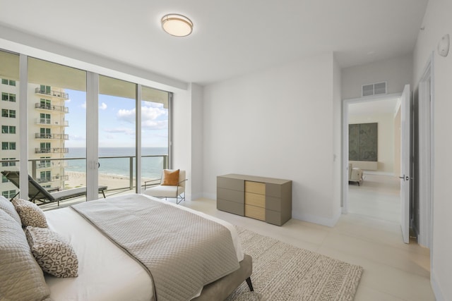 bedroom with a water view and floor to ceiling windows