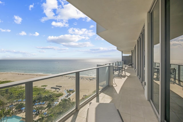 balcony featuring a view of the beach and a water view