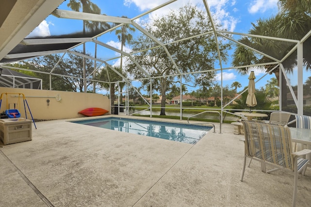 view of swimming pool featuring glass enclosure and a patio area