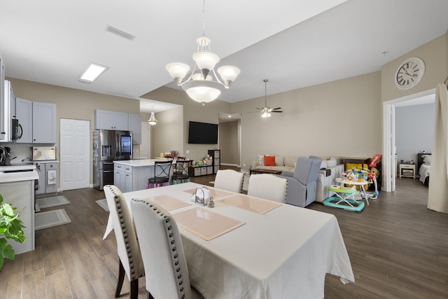 dining space featuring ceiling fan with notable chandelier and dark hardwood / wood-style floors