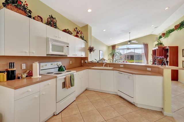 kitchen featuring white appliances, vaulted ceiling, kitchen peninsula, ceiling fan, and white cabinetry