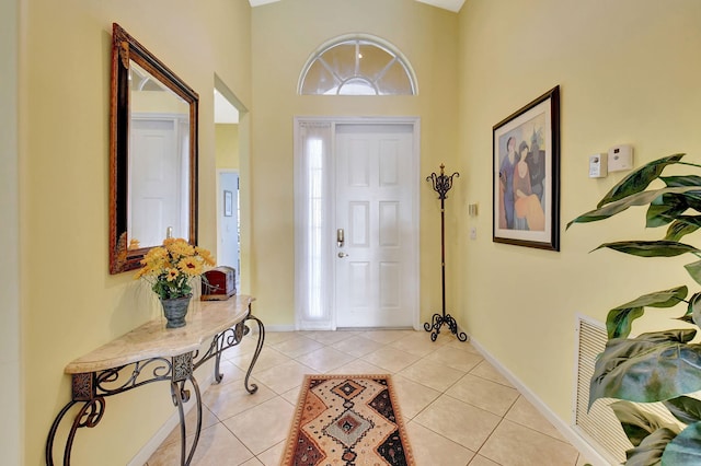 entryway featuring a towering ceiling and light tile patterned floors