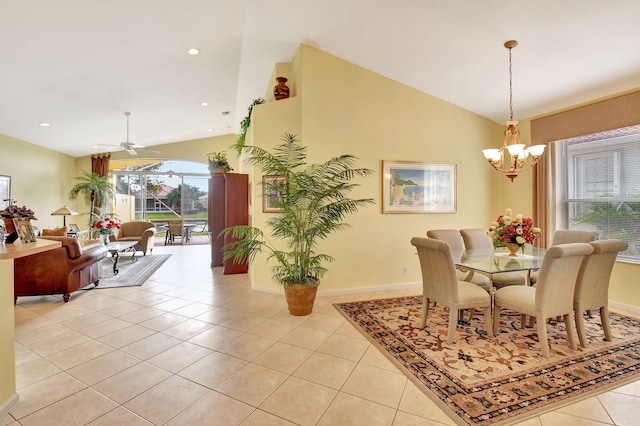 tiled dining space featuring lofted ceiling, a wealth of natural light, and ceiling fan with notable chandelier